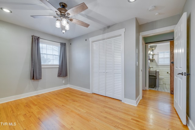 unfurnished bedroom with ceiling fan, a closet, and light hardwood / wood-style flooring