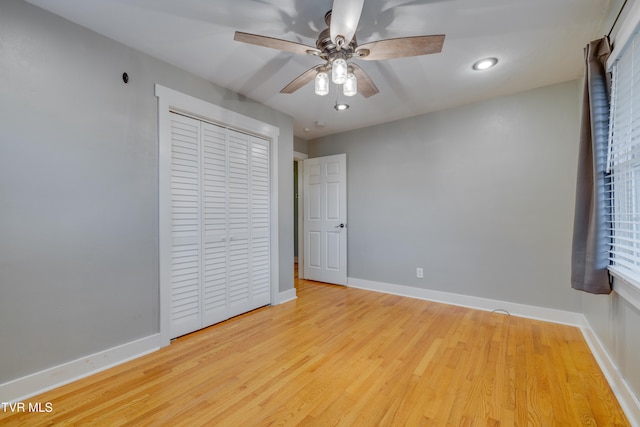 unfurnished bedroom featuring a closet, light hardwood / wood-style floors, and ceiling fan