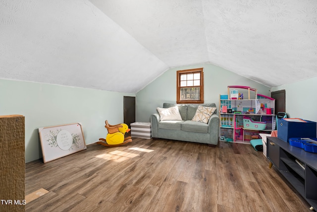 additional living space featuring a textured ceiling, dark hardwood / wood-style flooring, and lofted ceiling