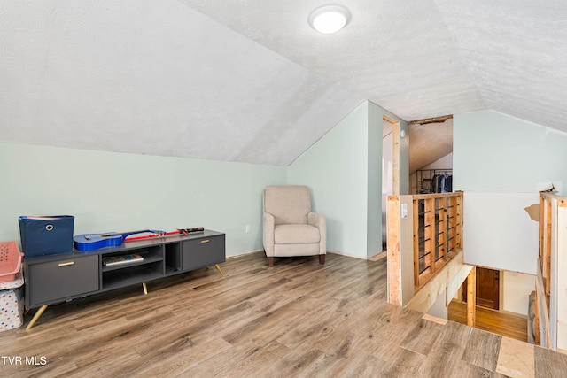 bonus room featuring wood-type flooring, a textured ceiling, and vaulted ceiling