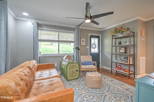 living room with ceiling fan, wood-type flooring, and ornamental molding