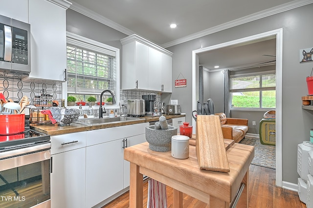 kitchen with white cabinets, sink, dark hardwood / wood-style floors, decorative backsplash, and appliances with stainless steel finishes