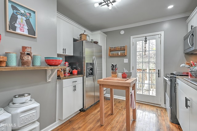 kitchen featuring white cabinetry, ornamental molding, stainless steel appliances, and light hardwood / wood-style floors