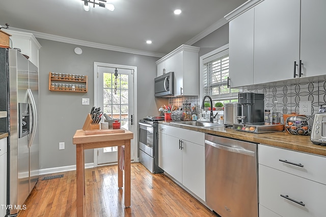 kitchen with a healthy amount of sunlight, sink, stainless steel appliances, and light hardwood / wood-style flooring