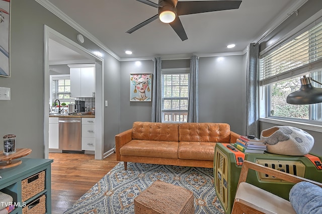 living room featuring wood-type flooring, ceiling fan, and crown molding