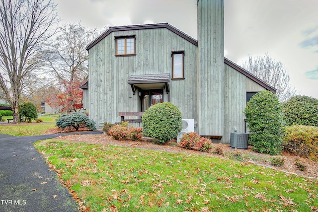 view of side of home featuring a lawn and central air condition unit