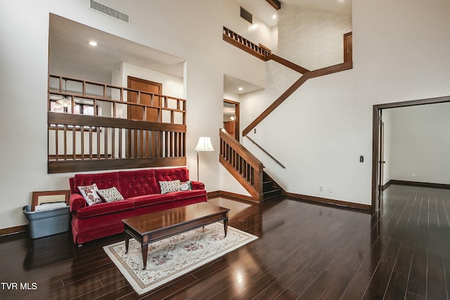 living room featuring dark hardwood / wood-style flooring and a high ceiling