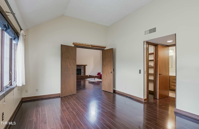 empty room featuring lofted ceiling and dark wood-type flooring