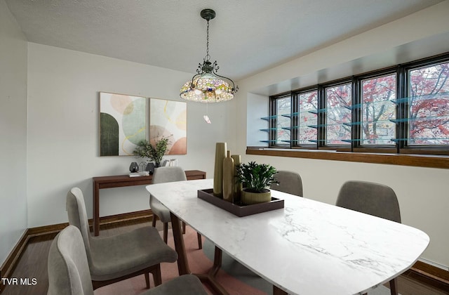 dining room featuring a textured ceiling and dark hardwood / wood-style flooring