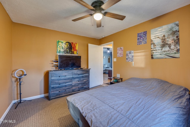 carpeted bedroom with ceiling fan and a textured ceiling