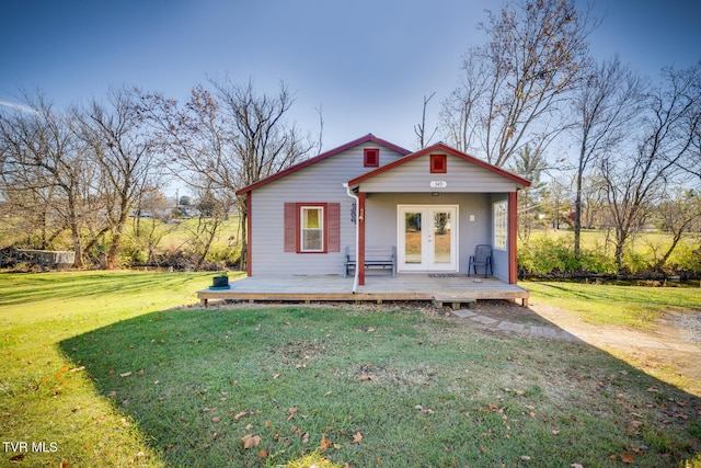 bungalow-style home with french doors and a front lawn