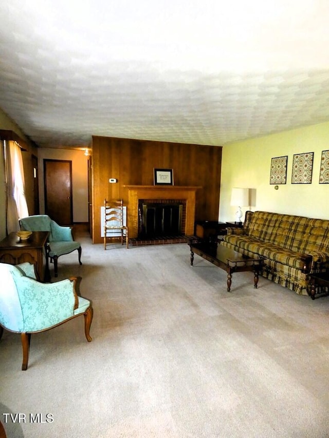 living room featuring wood walls, a fireplace, and light carpet