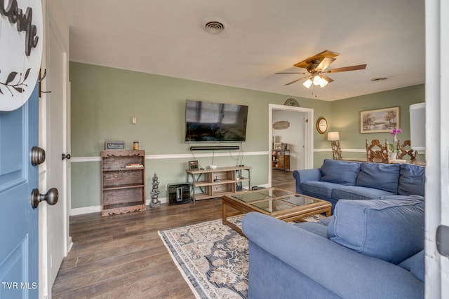 living room with dark hardwood / wood-style floors and ceiling fan