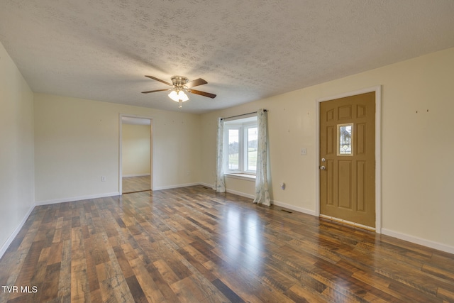 interior space with a textured ceiling, ceiling fan, and dark wood-type flooring