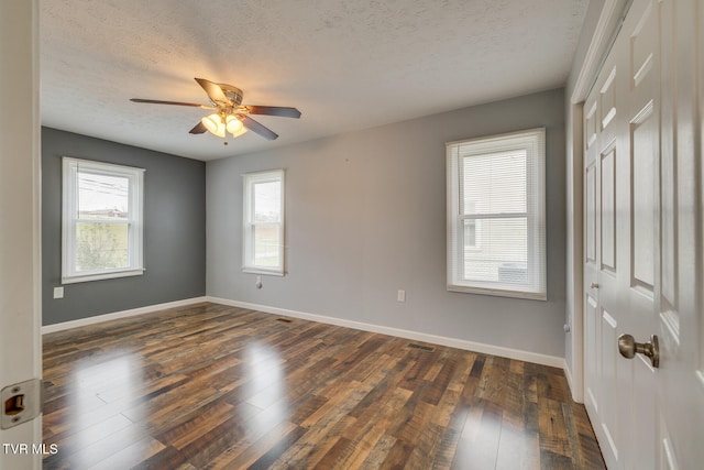 spare room with ceiling fan, dark hardwood / wood-style flooring, and a textured ceiling