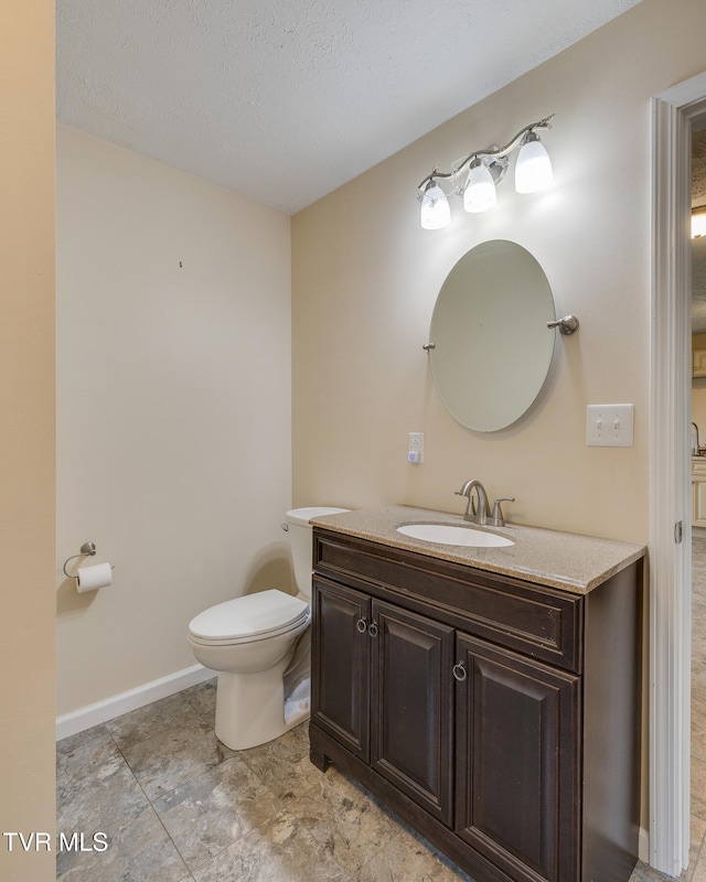 bathroom featuring vanity, a textured ceiling, and toilet