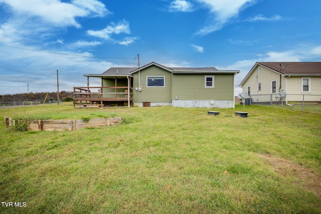 rear view of property with a yard and a wooden deck