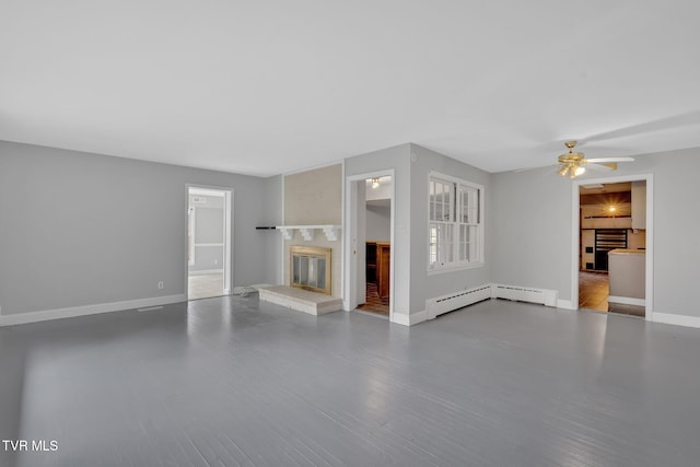 unfurnished living room with hardwood / wood-style flooring, ceiling fan, and a baseboard heating unit