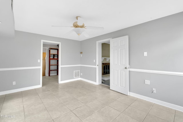 tiled spare room featuring ceiling fan