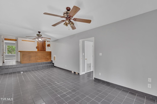 unfurnished living room with dark tile patterned flooring and ceiling fan