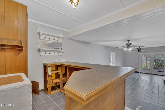 kitchen featuring tile countertops, french doors, ceiling fan, light tile patterned floors, and ornamental molding