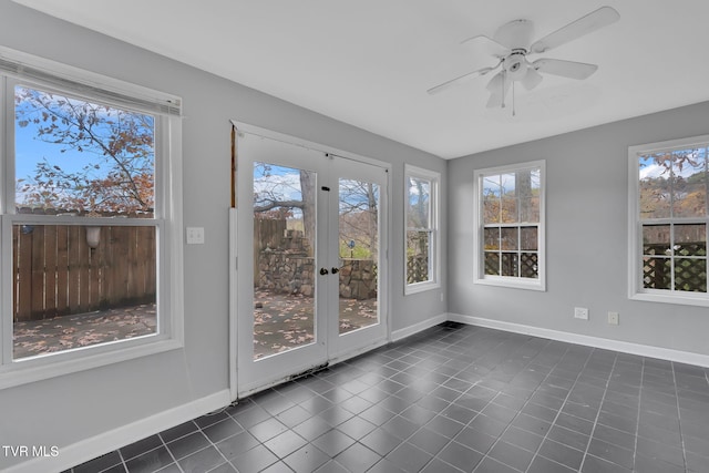 unfurnished sunroom featuring ceiling fan