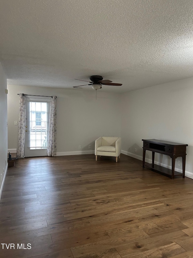 unfurnished room featuring ceiling fan, dark hardwood / wood-style flooring, and a textured ceiling