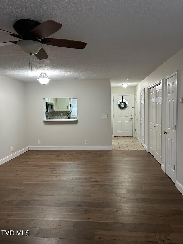 foyer entrance with ceiling fan, hardwood / wood-style floors, and a textured ceiling