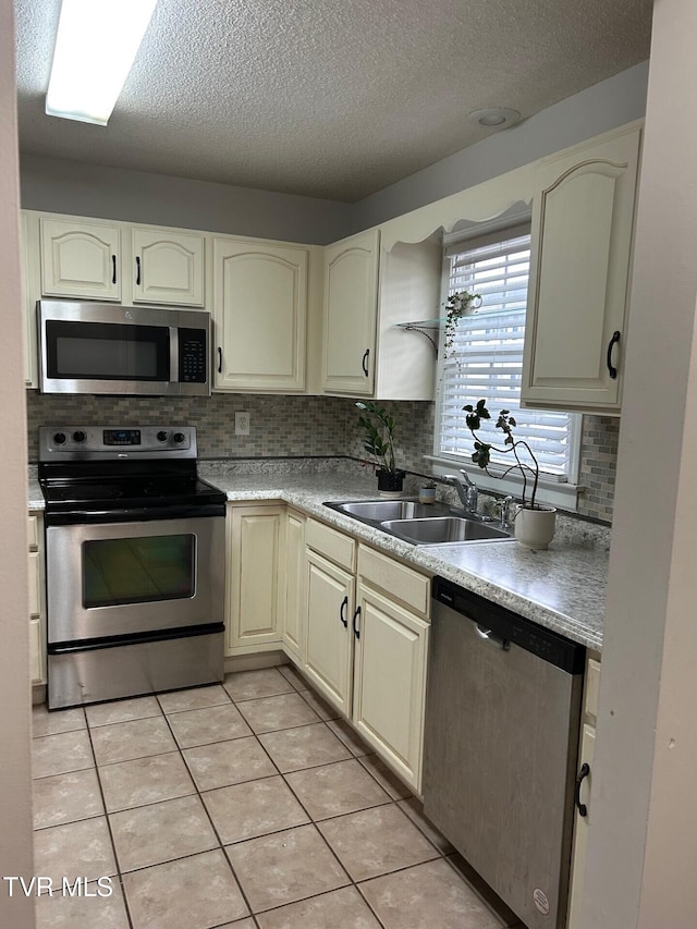 152 Gray Station Rd Unit 18, Gray, TN 37615 - kitchen with appliances with stainless steel finishes, tasteful backsplash, light tile patterned floors, a textured ceiling, and cream cabinetry