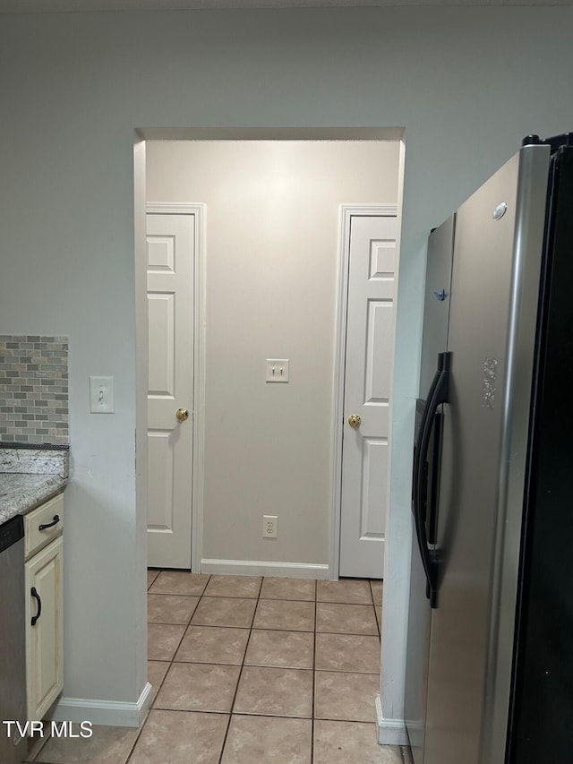 kitchen featuring decorative backsplash, light tile patterned flooring, and stainless steel appliances