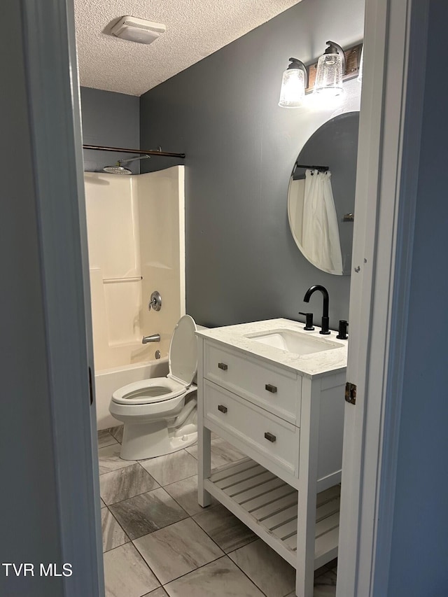 full bathroom featuring vanity, toilet, a textured ceiling, and shower / washtub combination