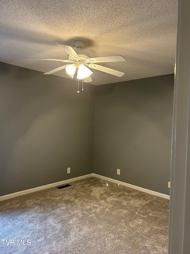 spare room featuring a textured ceiling, carpet floors, and ceiling fan