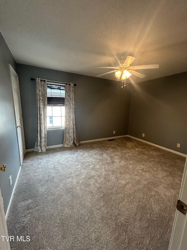 carpeted spare room with ceiling fan and a textured ceiling