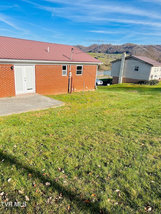 rear view of property featuring a lawn and a patio