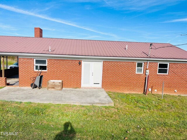 rear view of property featuring a yard and a patio area