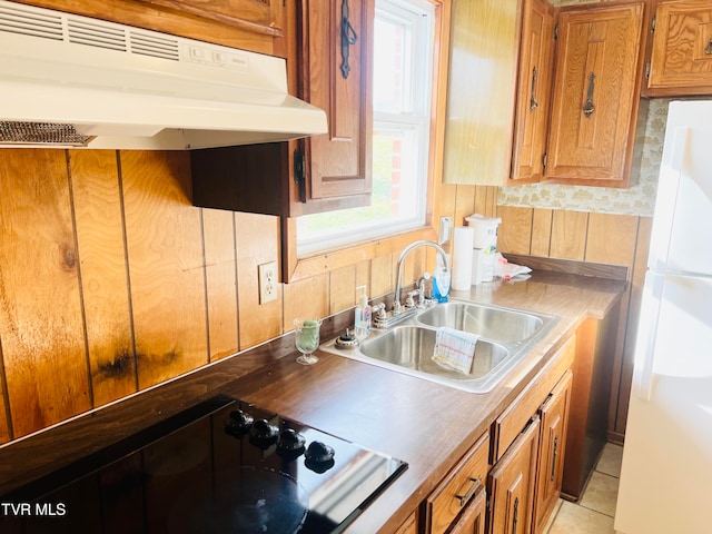 kitchen featuring stovetop, white refrigerator, plenty of natural light, and sink