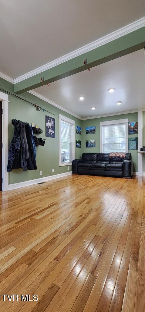 unfurnished living room featuring crown molding, hardwood / wood-style floors, and plenty of natural light