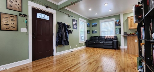 entrance foyer featuring crown molding and light wood-type flooring