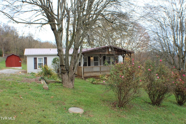 view of front of house featuring a front lawn, a porch, and a storage unit