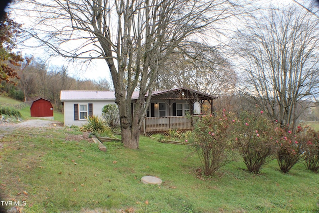 view of front of property featuring a front lawn, a porch, and a storage unit