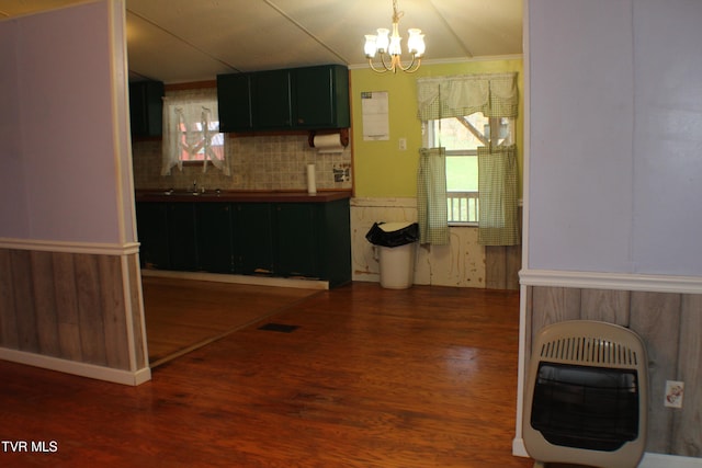 kitchen featuring hanging light fixtures, dark hardwood / wood-style floors, decorative backsplash, a notable chandelier, and heating unit