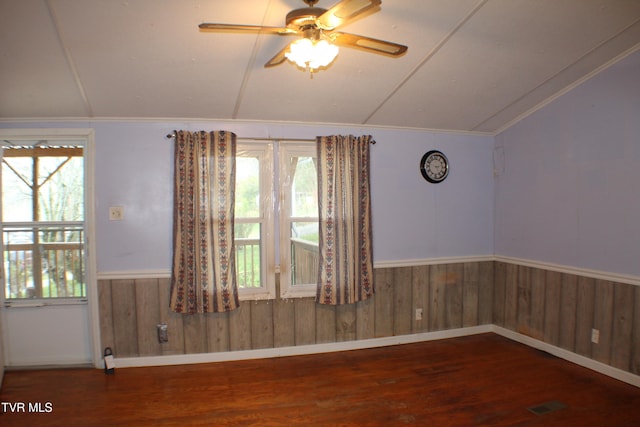 unfurnished room with wooden walls, dark hardwood / wood-style flooring, ceiling fan, and vaulted ceiling