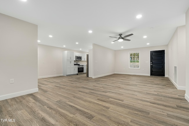 unfurnished living room with light wood-type flooring and ceiling fan