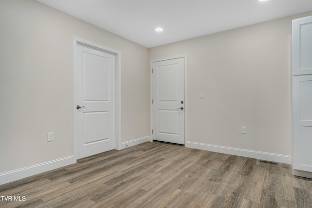 unfurnished room with hardwood / wood-style floors