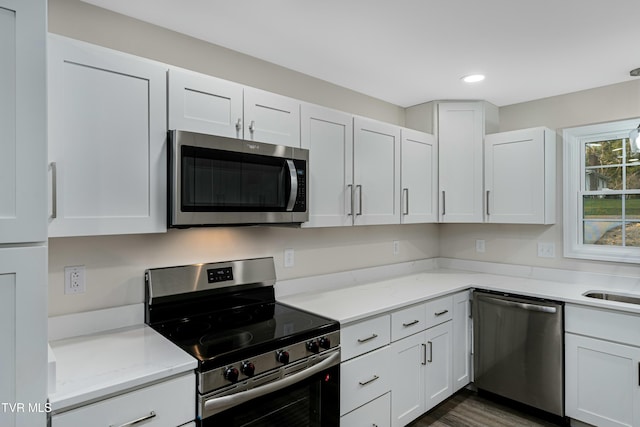 kitchen featuring white cabinetry, light stone counters, and appliances with stainless steel finishes