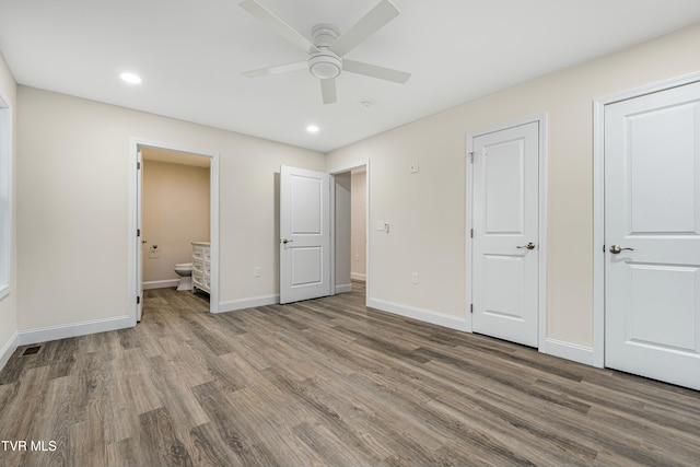 unfurnished bedroom featuring hardwood / wood-style flooring, ceiling fan, and connected bathroom