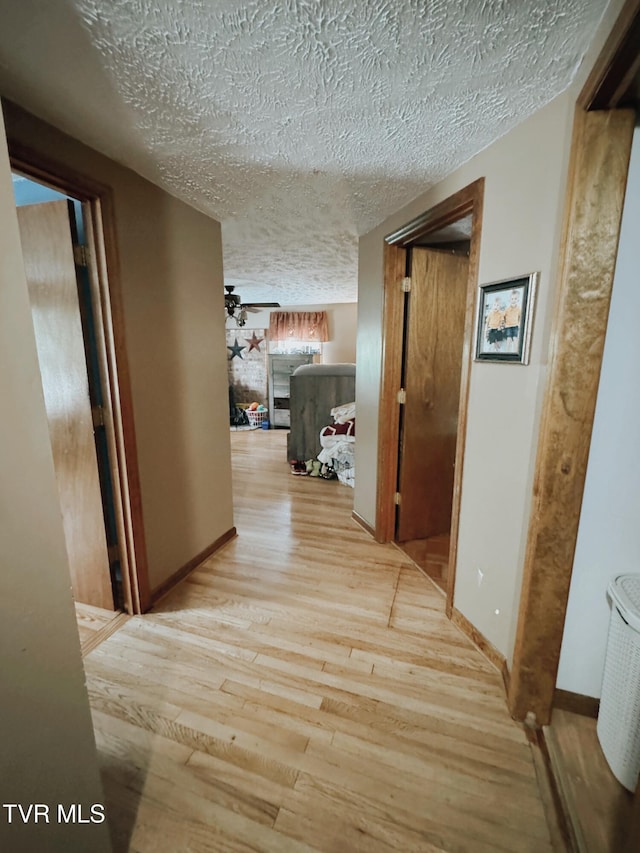 hallway featuring a textured ceiling and light wood-type flooring