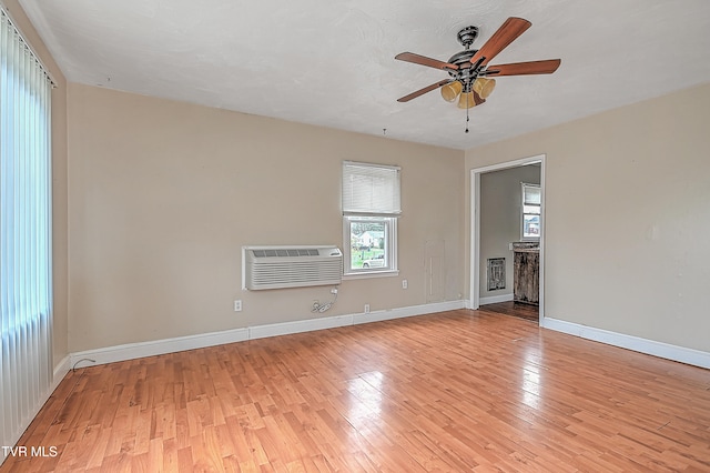 unfurnished living room with a fireplace, light hardwood / wood-style floors, an AC wall unit, and ceiling fan