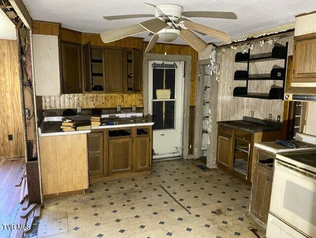 kitchen with ceiling fan, wood walls, and white range