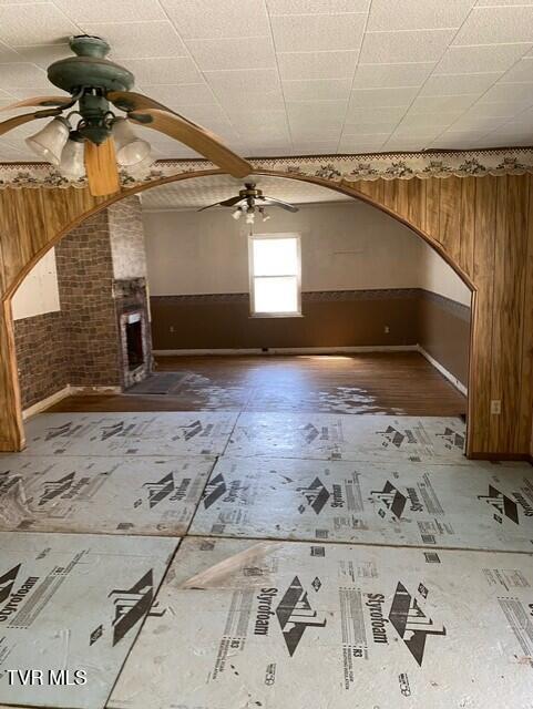 5332 Stonega Rd, Appalachia, VA 24216 - bonus room with ceiling fan, wood walls, wainscoting, and arched walkways